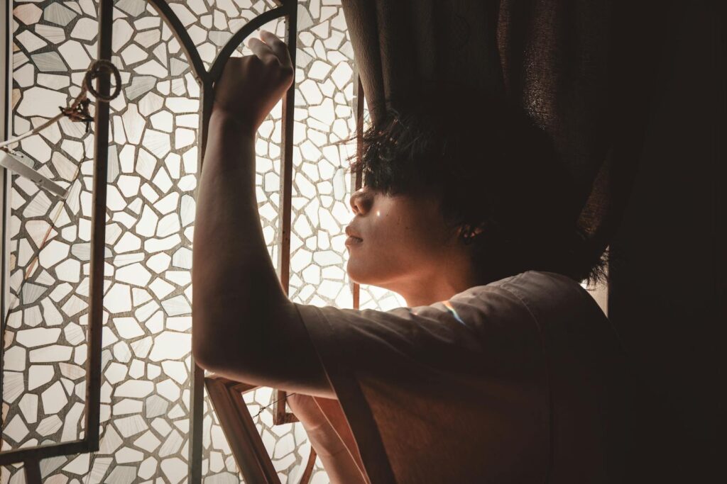 Person sitting calmly by a window in quiet reflection, representing what to do after taking the Rice Purity Test