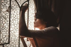 Person sitting calmly by a window in quiet reflection, representing what to do after taking the Rice Purity Test